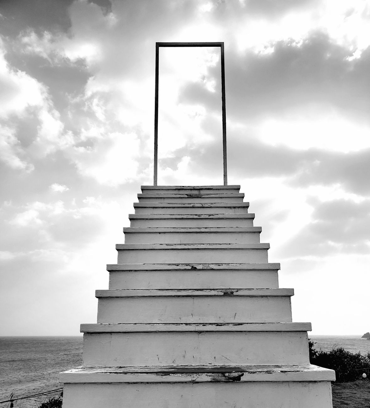 black and white picture of steps leading to nowhere on the beach