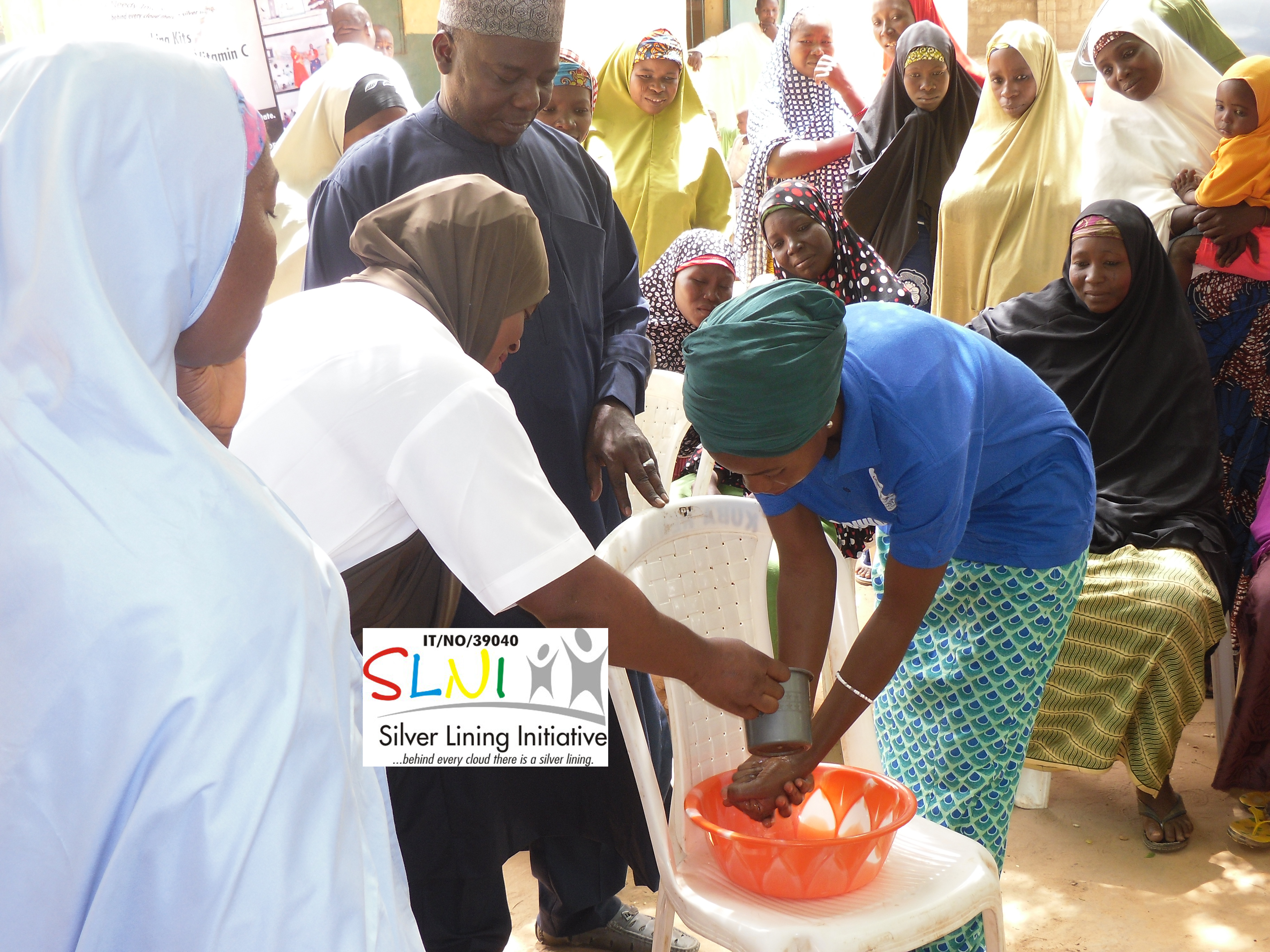 SLNI staff demonstrating proper handwashing to women in Ambursa village in Kebbi state