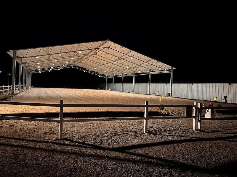 Covered riding arena illuminated for safe horseback riding and training after dark.