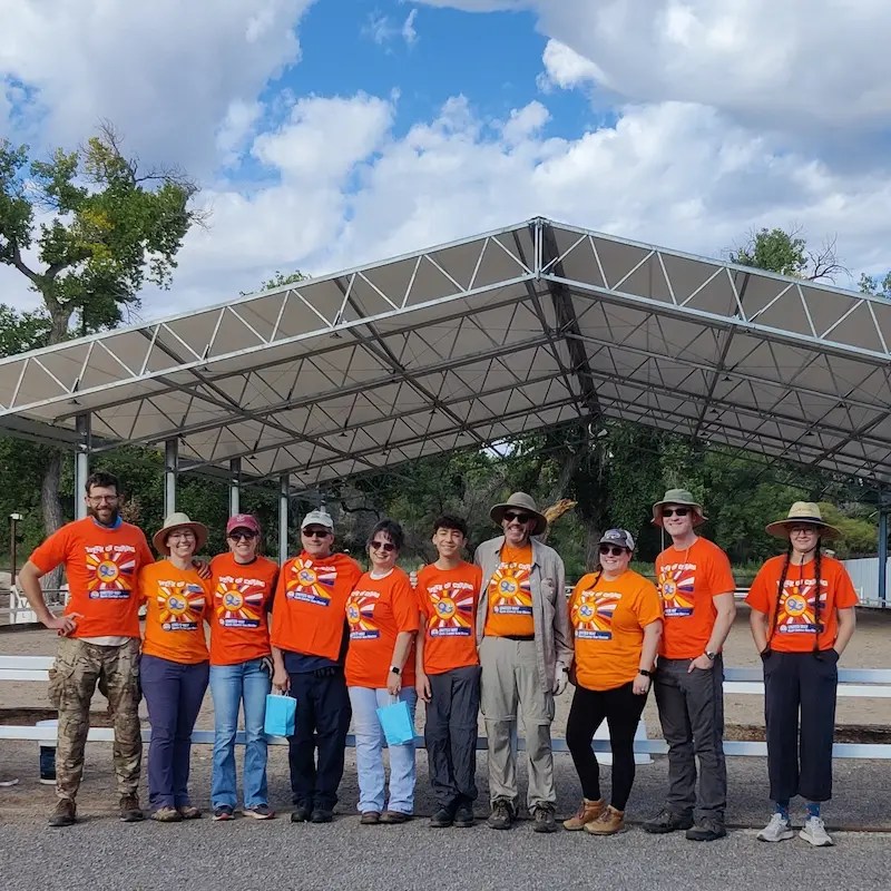 The Silver Trophy Equine team standing in front of a covered riding arena during a company event.