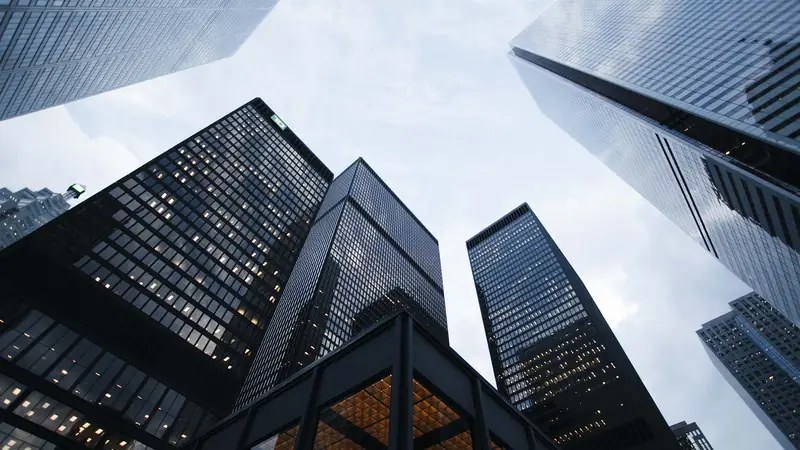 Glass office towers viewed from street level, representing the office and commercial removals handled by Simple Removals & Logistics