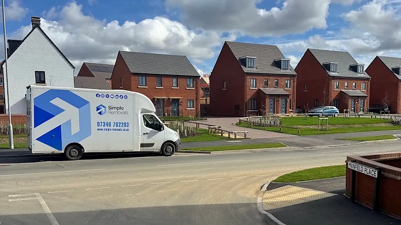 Simple Removals & Logistics van driving through a Northamptonshire new-build estate during a house move