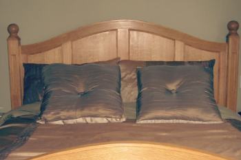 wooden bed frame with brown bedsheets