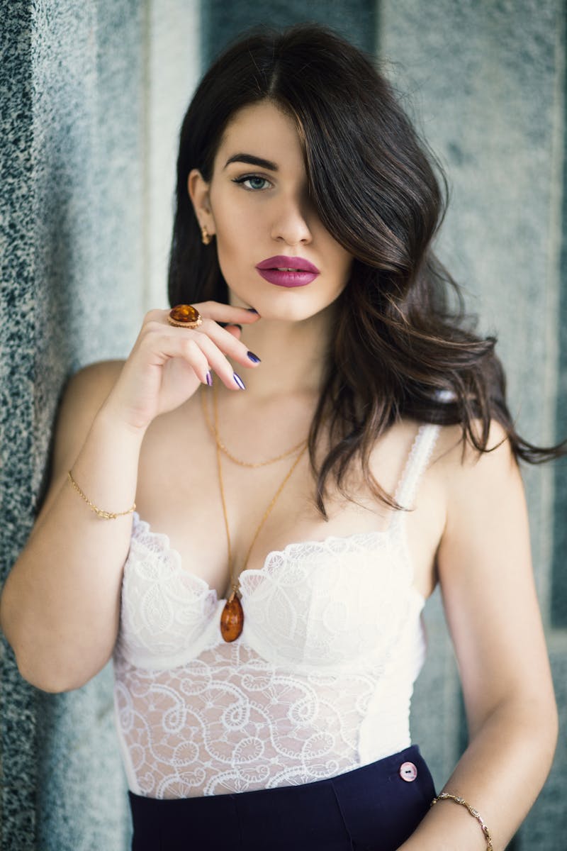 Elegant portrait of a brunette woman with jewelry and fashionable attire.