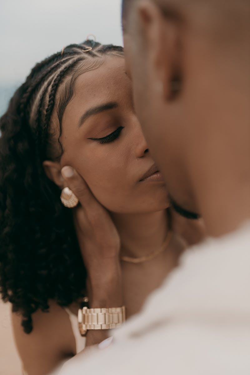 A tender moment captured in an intimate close-up of a couple embracing outdoors.