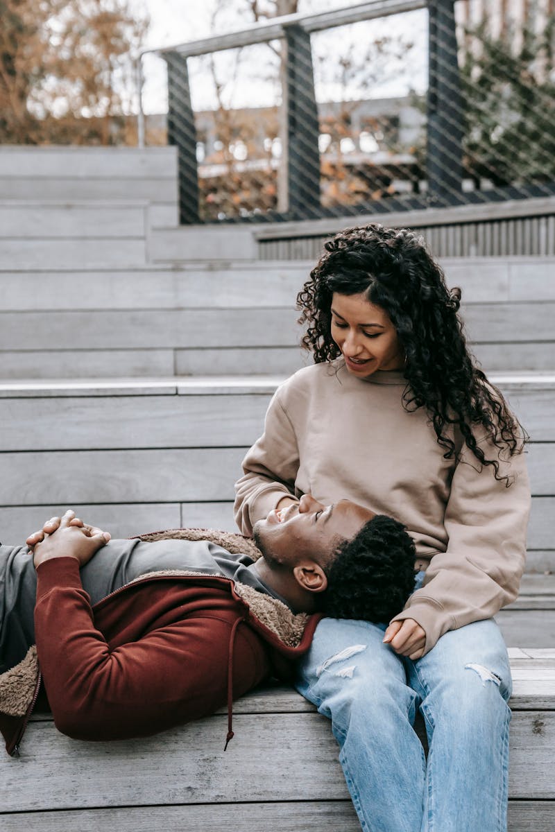 Romantic couple enjoying tender moment outdoors on urban steps.