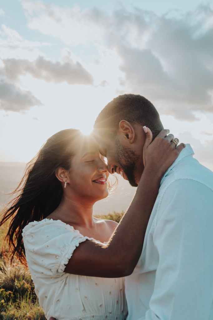 A romantic couple embraces at sunset in Minas Gerais, capturing love and serenity amidst stunning scenery.