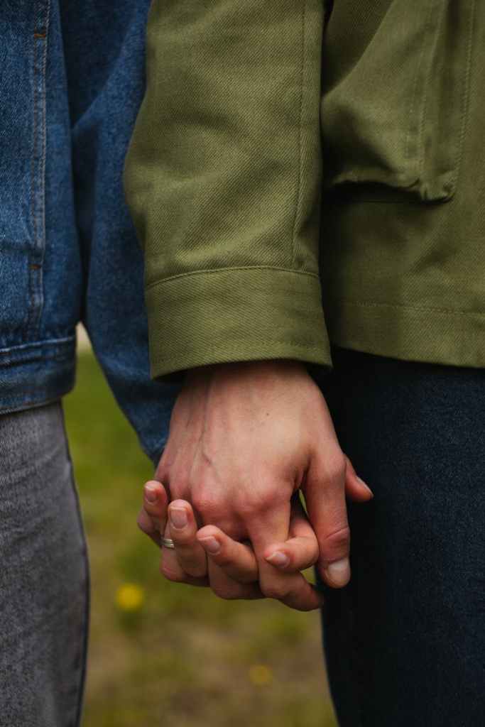 Intimate shot of a couple holding hands, showcasing love and connection.
