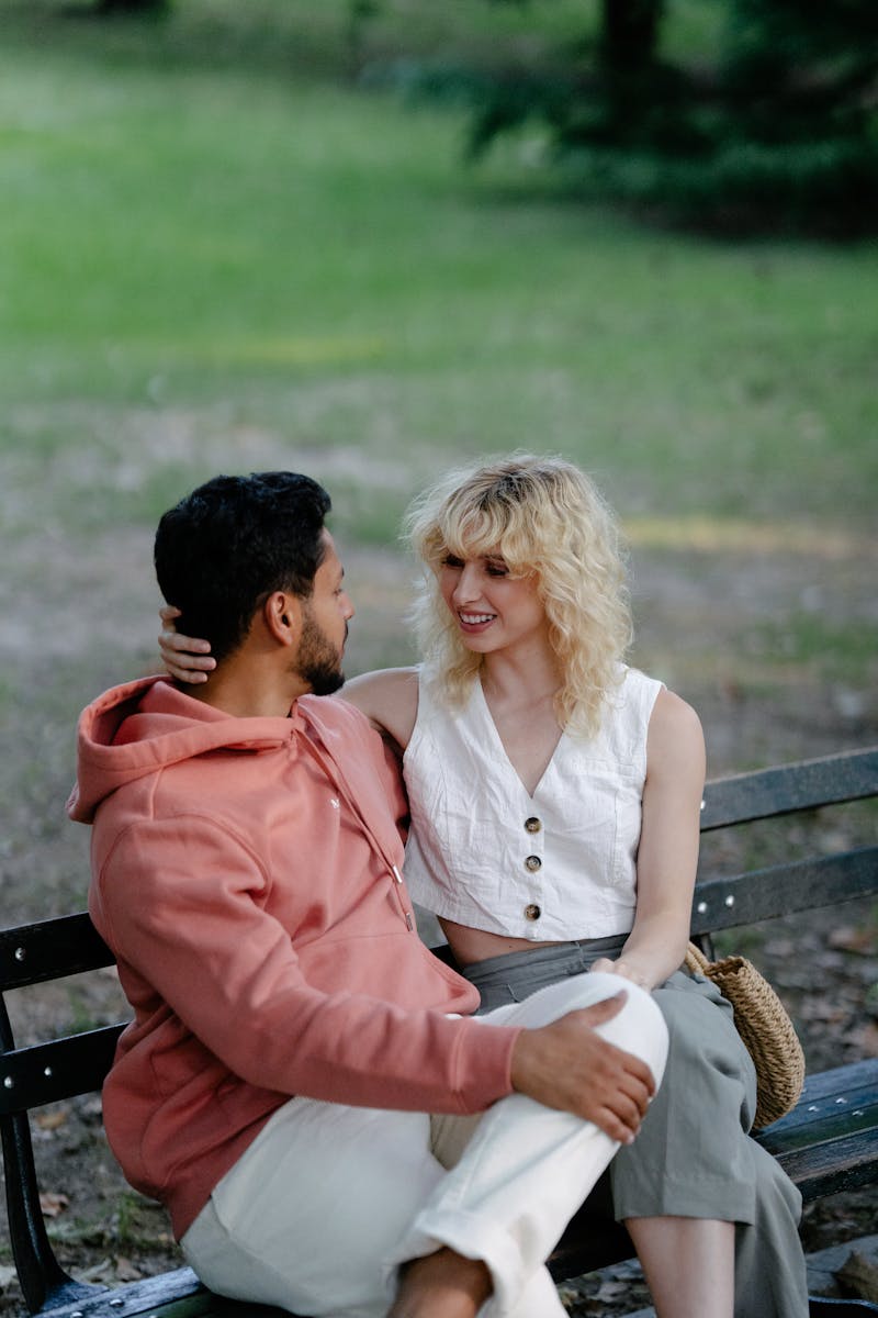 Happy couple enjoying a moment together on a park bench outdoors.