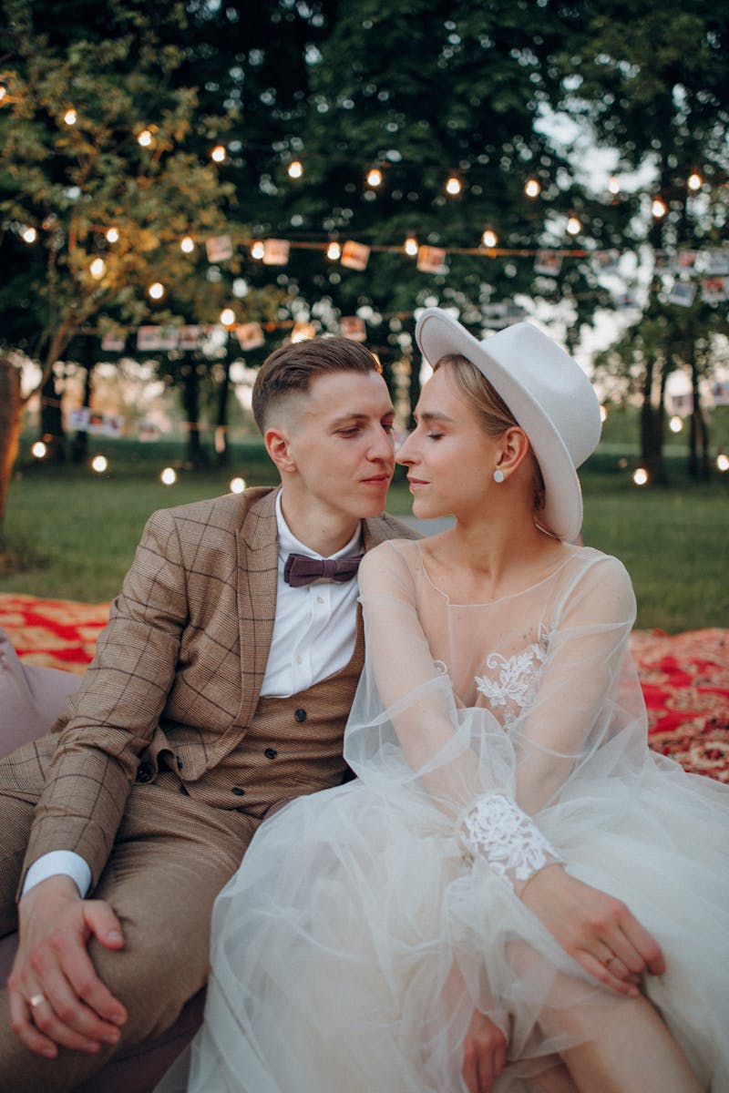 Charming outdoor wedding photo of newlywed couple in elegant attire, with romantic lighting.