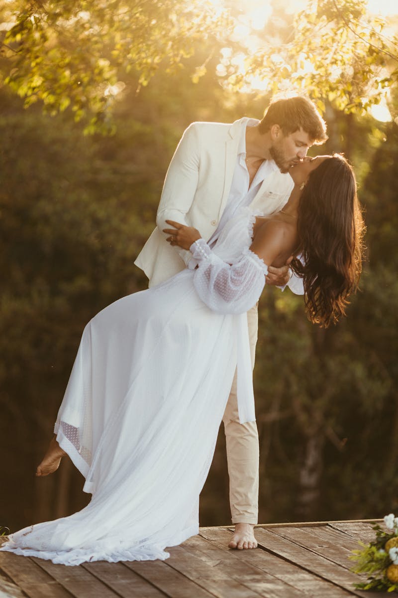 A couple shares a romantic dance outdoors under the warm glow of sunset.