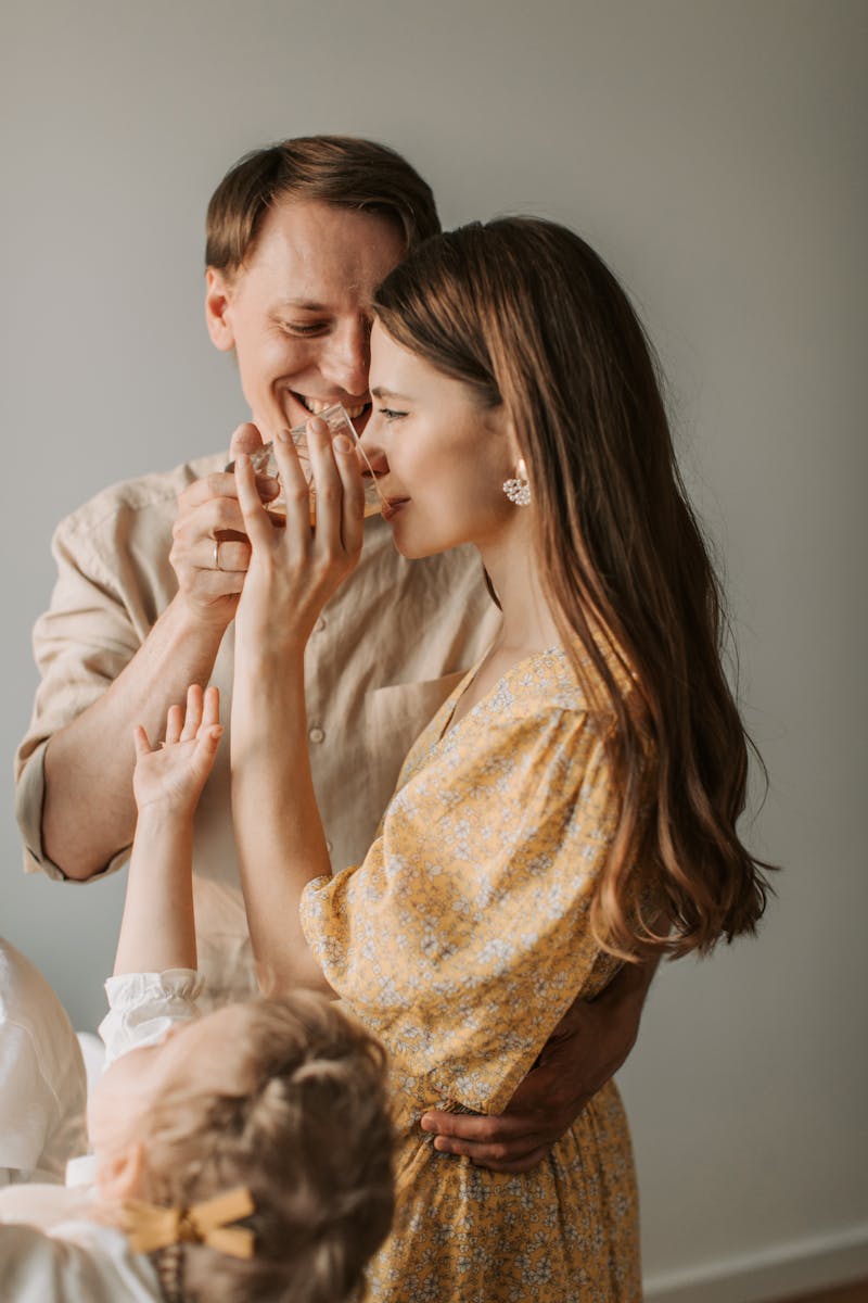 A loving couple shares a tender moment while enjoying a drink with their child.