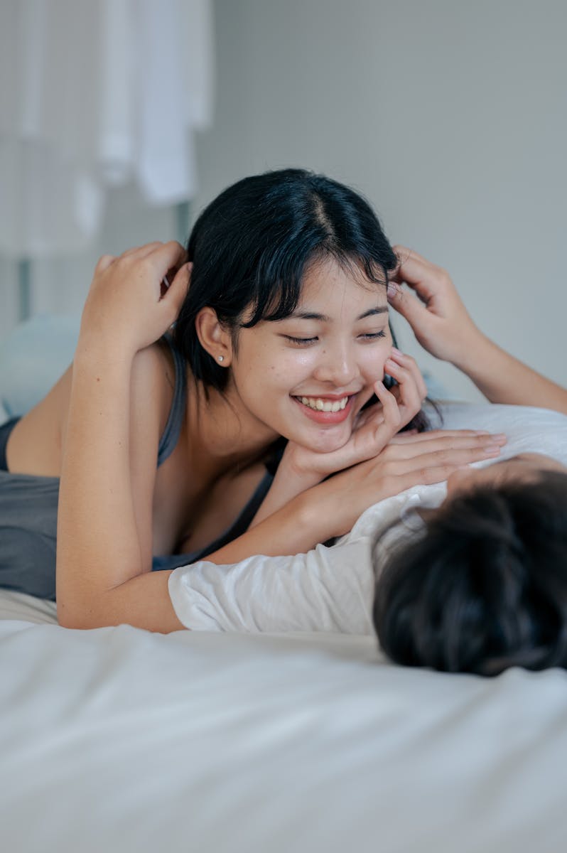 Happy couple lying in bed, enjoying a relaxing and intimate moment indoors.