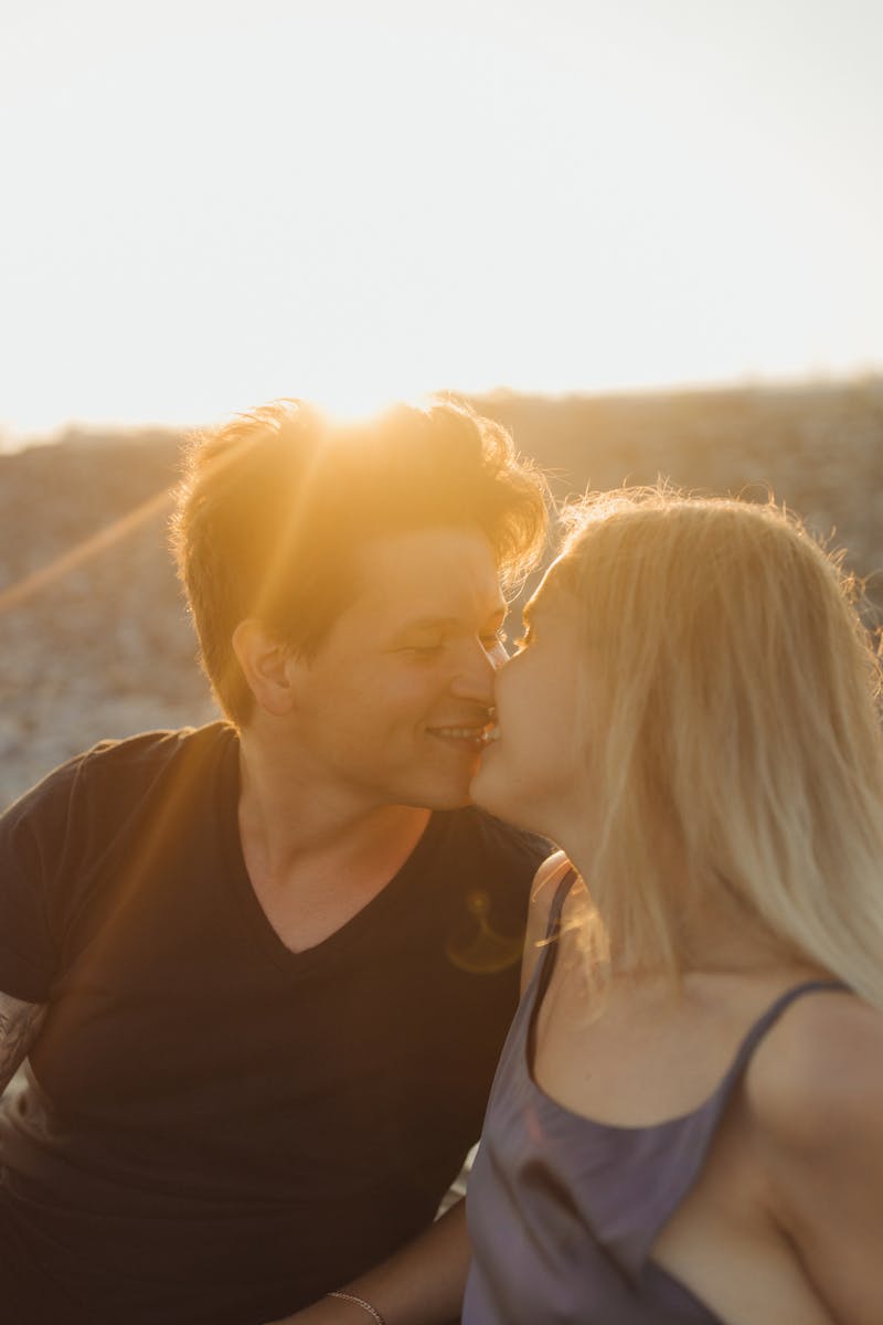 A couple shares a tender moment at sunset on the beach, embodying love and romance.
