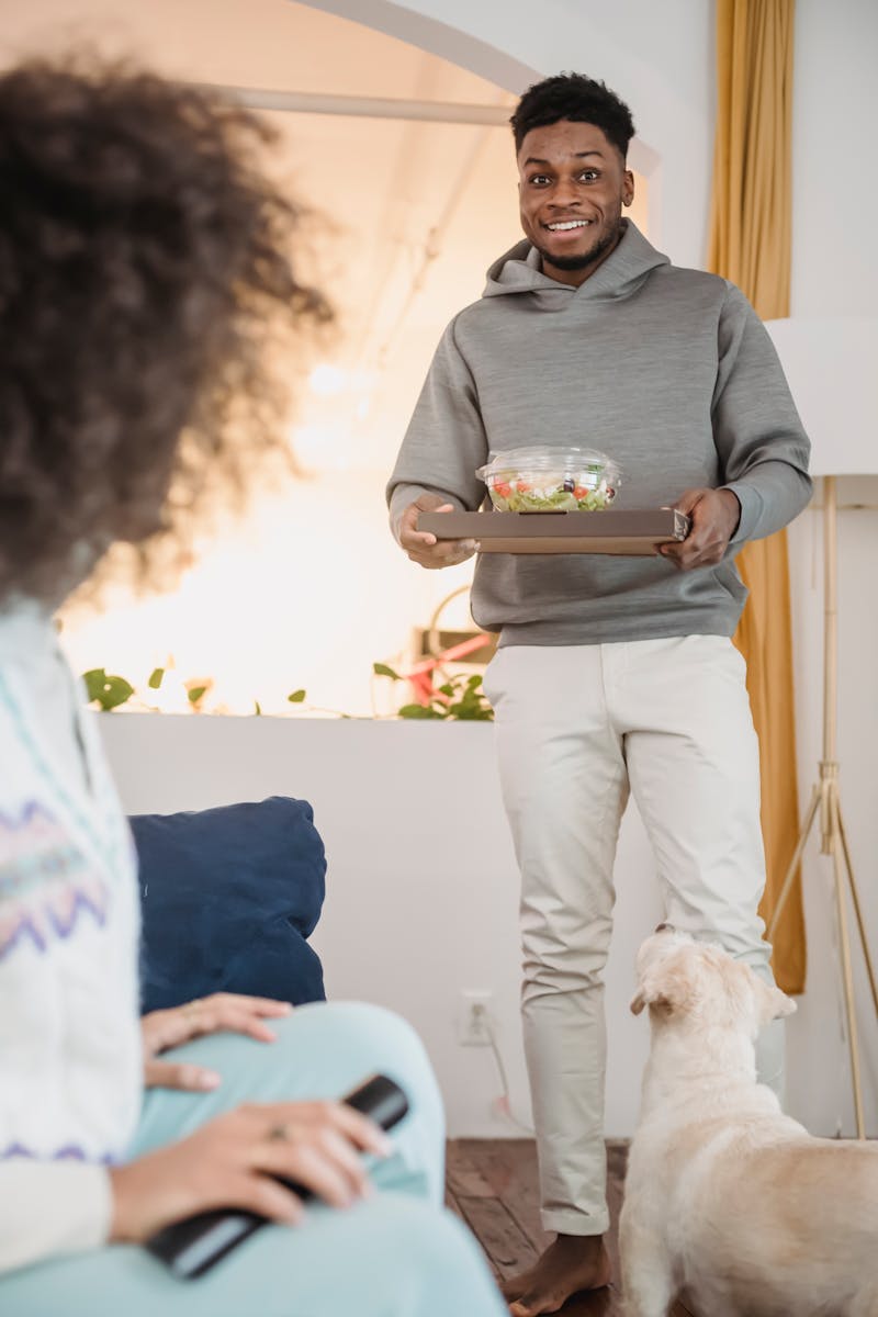 Smiling couple spending quality time at home with their dog and enjoying a healthy meal.