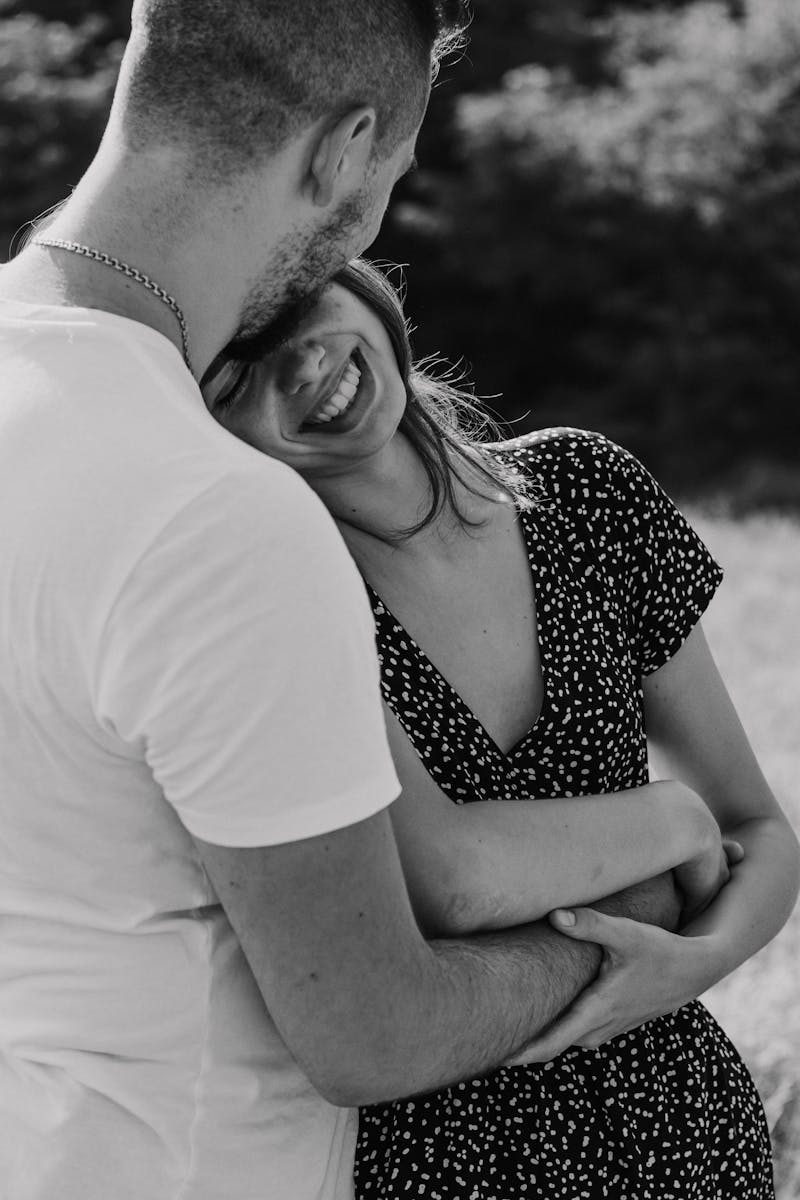 A happy couple embracing in an intimate, romantic moment captured in black and white.