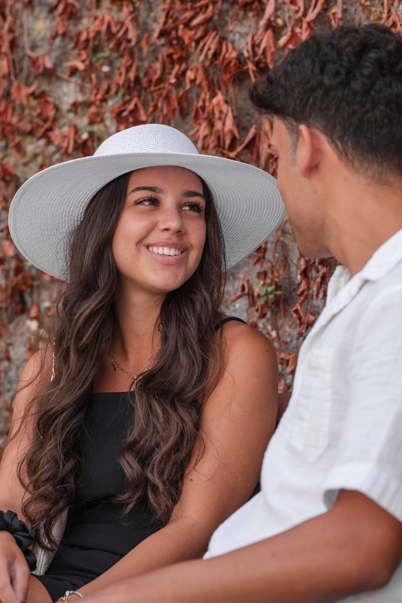 A smiling couple sitting together outdoors enjoying a bright summer day.