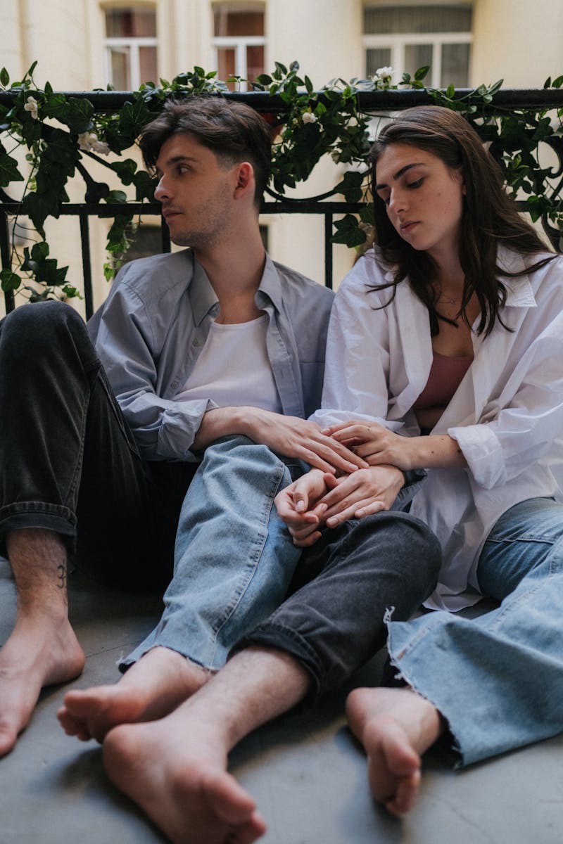 A serene moment of a couple sitting on a leafy balcony, sharing tender emotions.