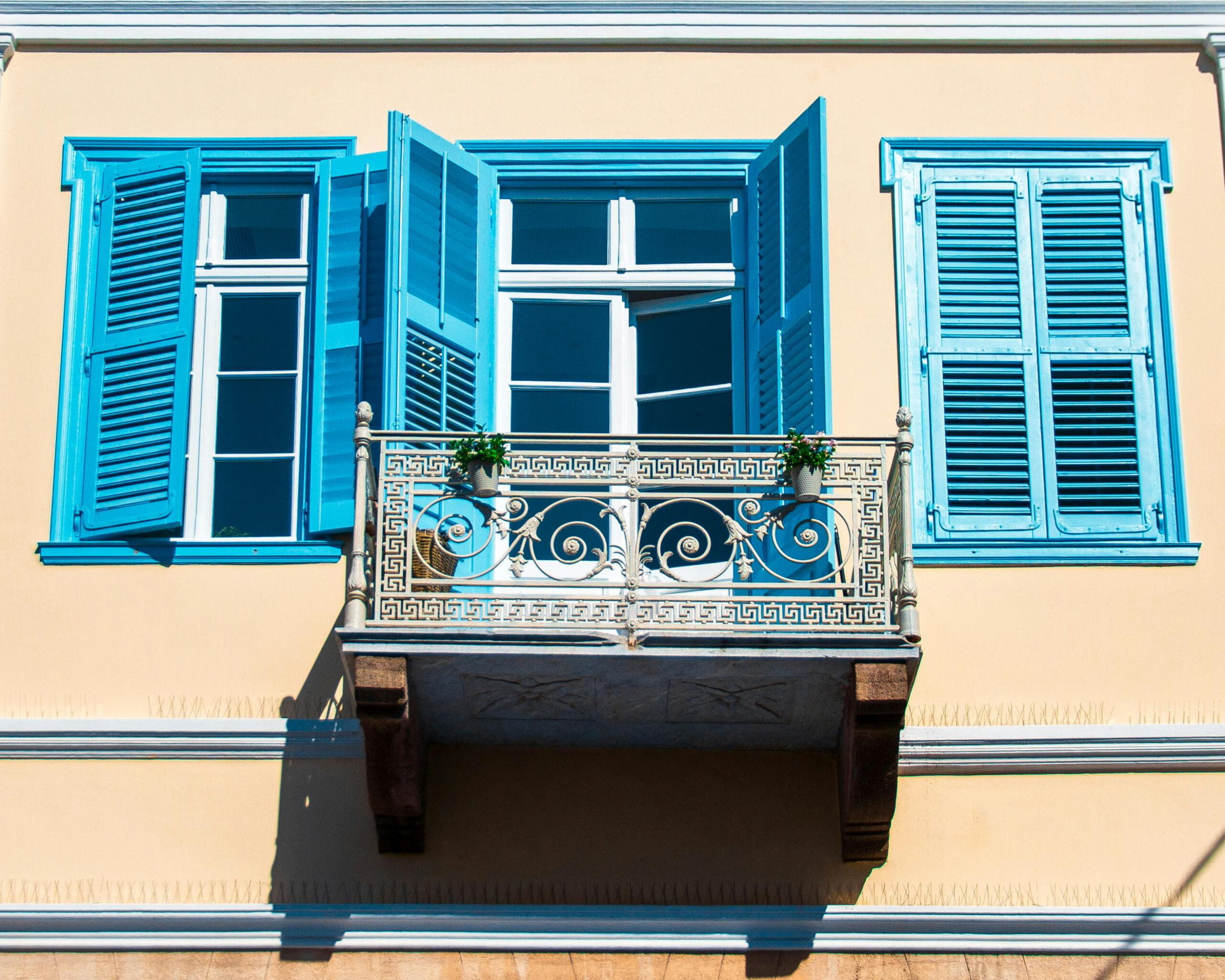Pebbledash Removal Ardsley - Elegant balcony with blue shutters and intricate railing design