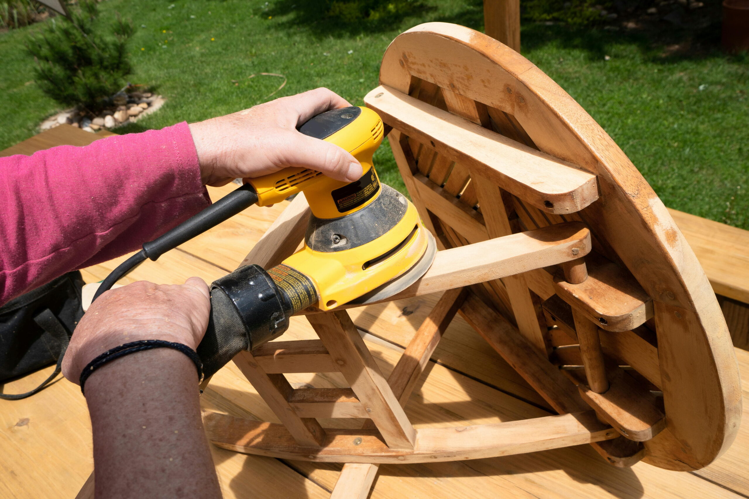 Preparation of wooden furniture for waterproofing services in Barnslis using a sander.