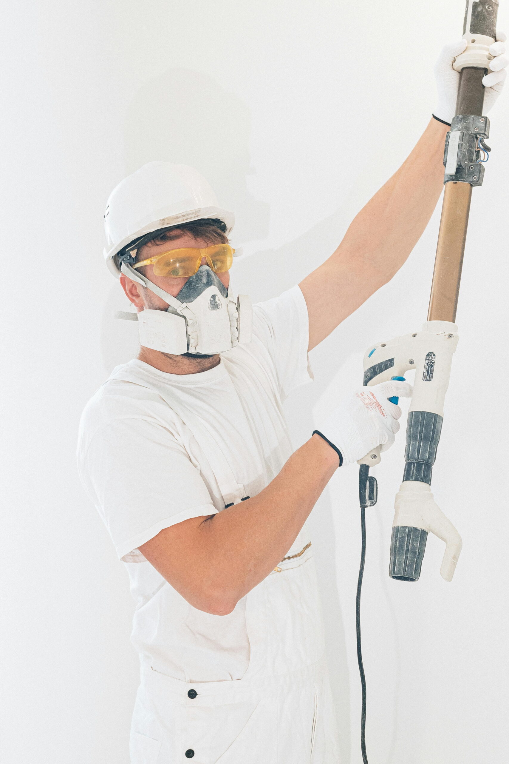 Worker using external render sprayer - common DIY rendering mistakes to avoid