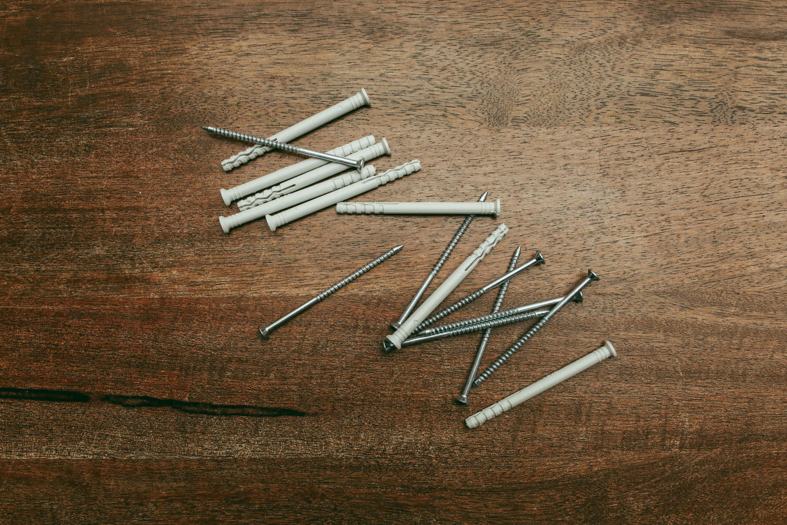 Wall plugs and screws arranged on wooden surface for improving EPC rating with EWI