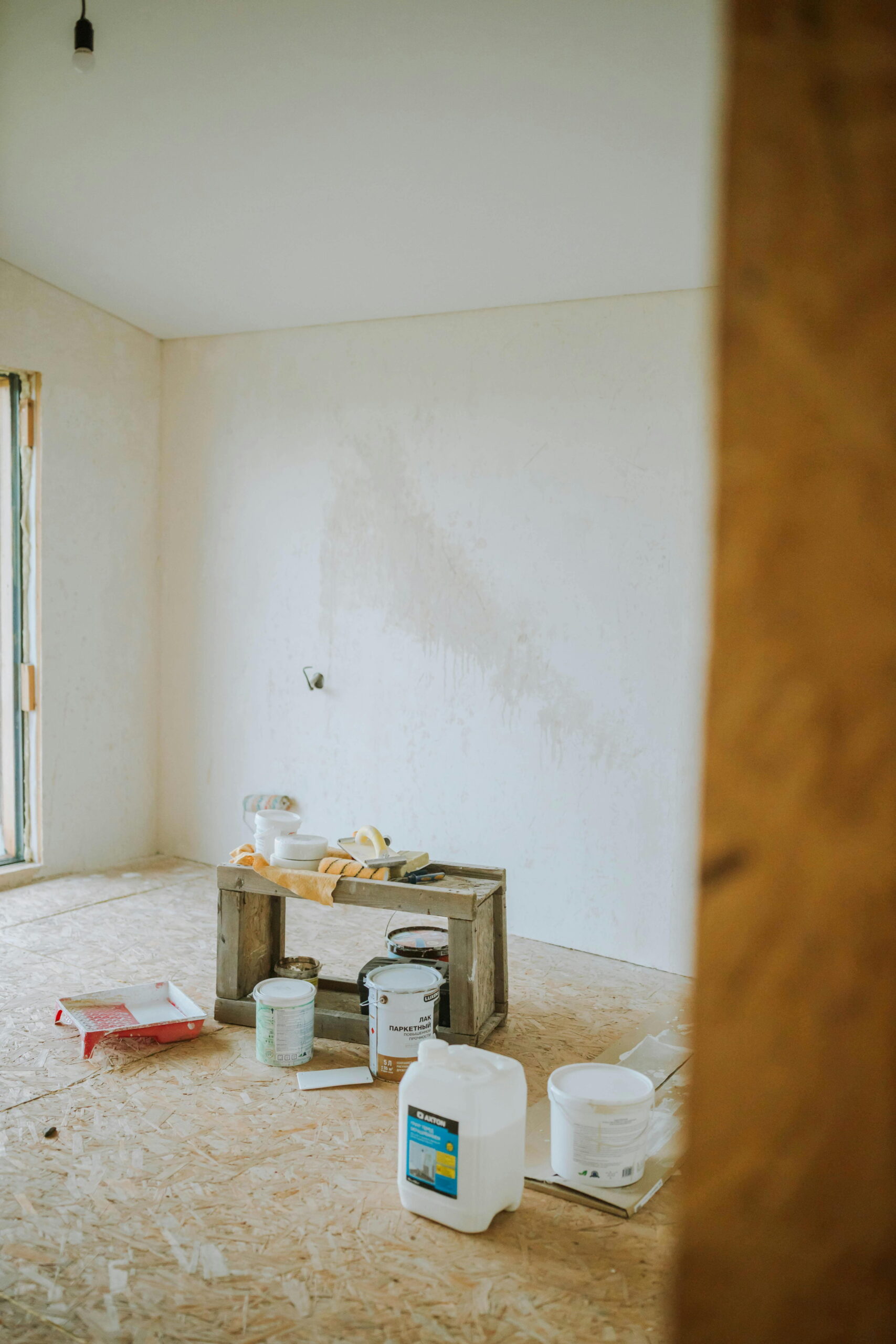 ladder safety while painting exteriors with paint buckets and tools arranged for secure access