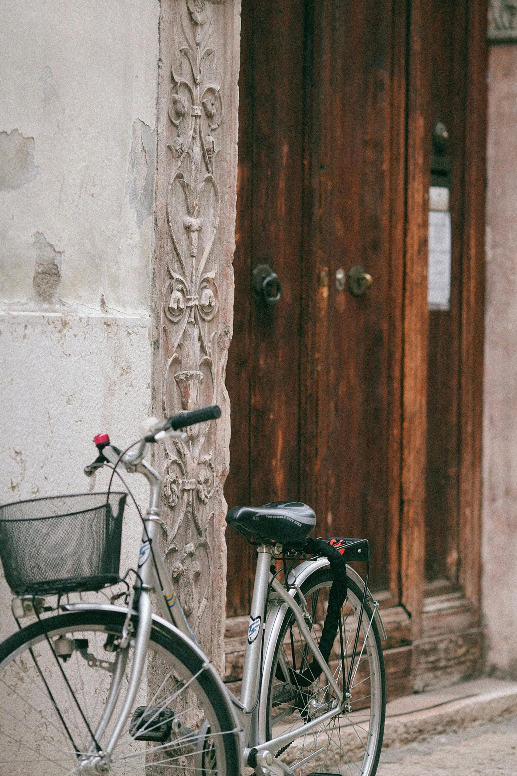 Silver bicycle parked against a rendered exterior wall showing wind chill effect on render curing