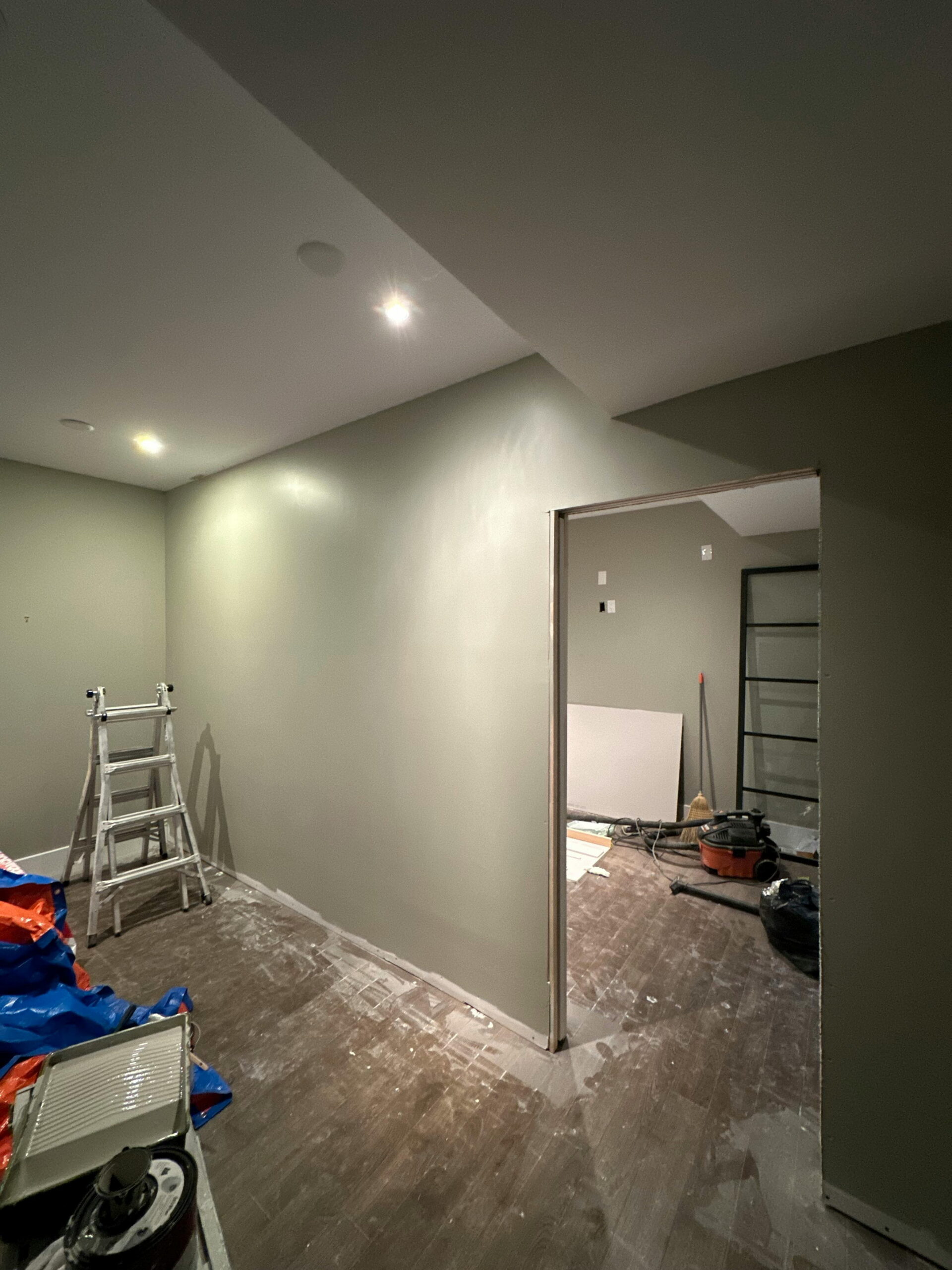 spotting early signs of render failure on interior plastered wall with ladder and tools