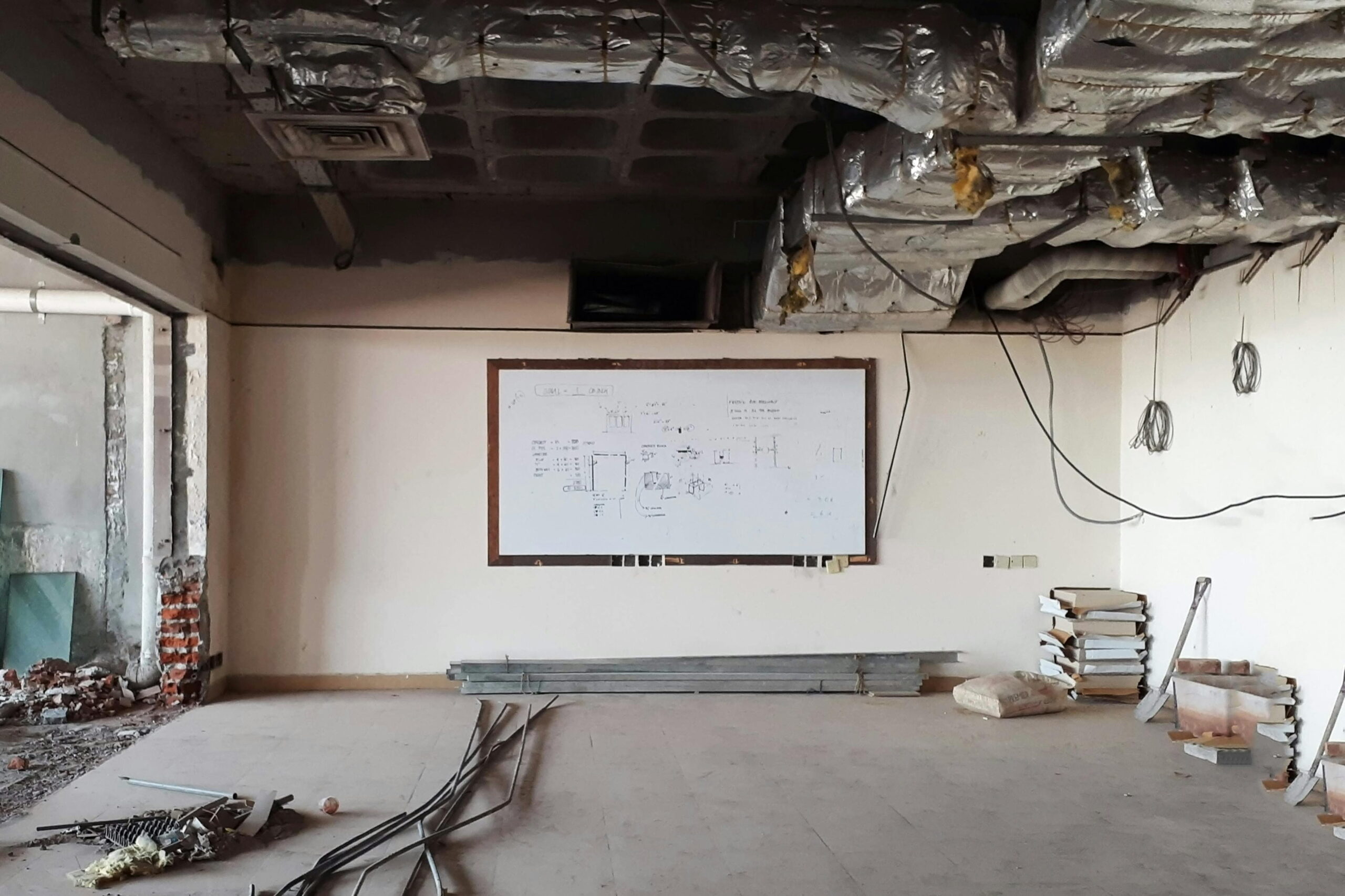 Photo illustrating five common DIY render mistakes in an internal construction site with exposed ducts and uneven plaster