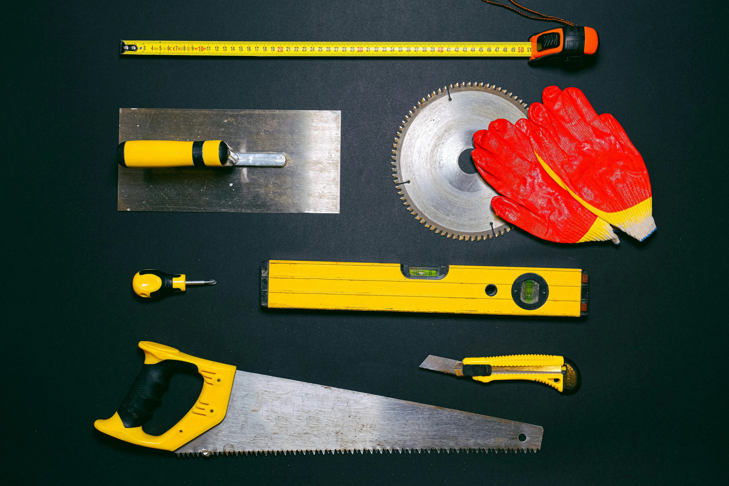 Ceresit ZU base-coat render review: professional tools including trowel, hand saw, spirit level, measuring tape, and safety gloves for plastering and rendering services