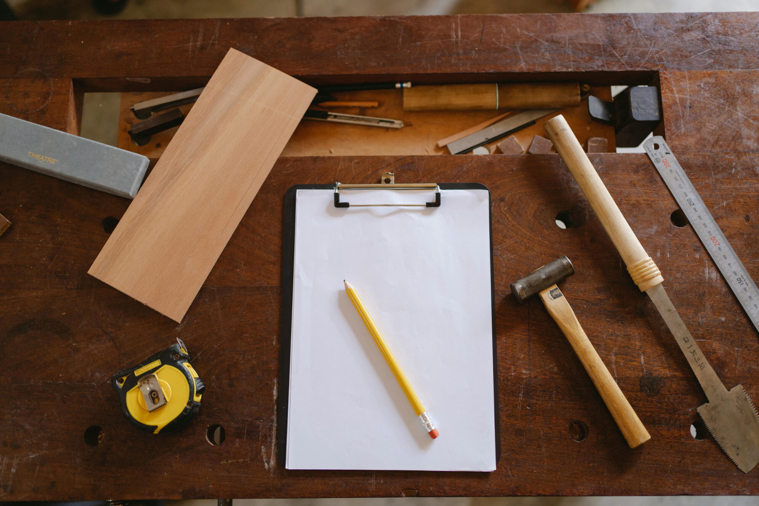 Workbench setup with carpentry tools and measuring devices used in door manufacturing for PAS-24 security requirements compliance