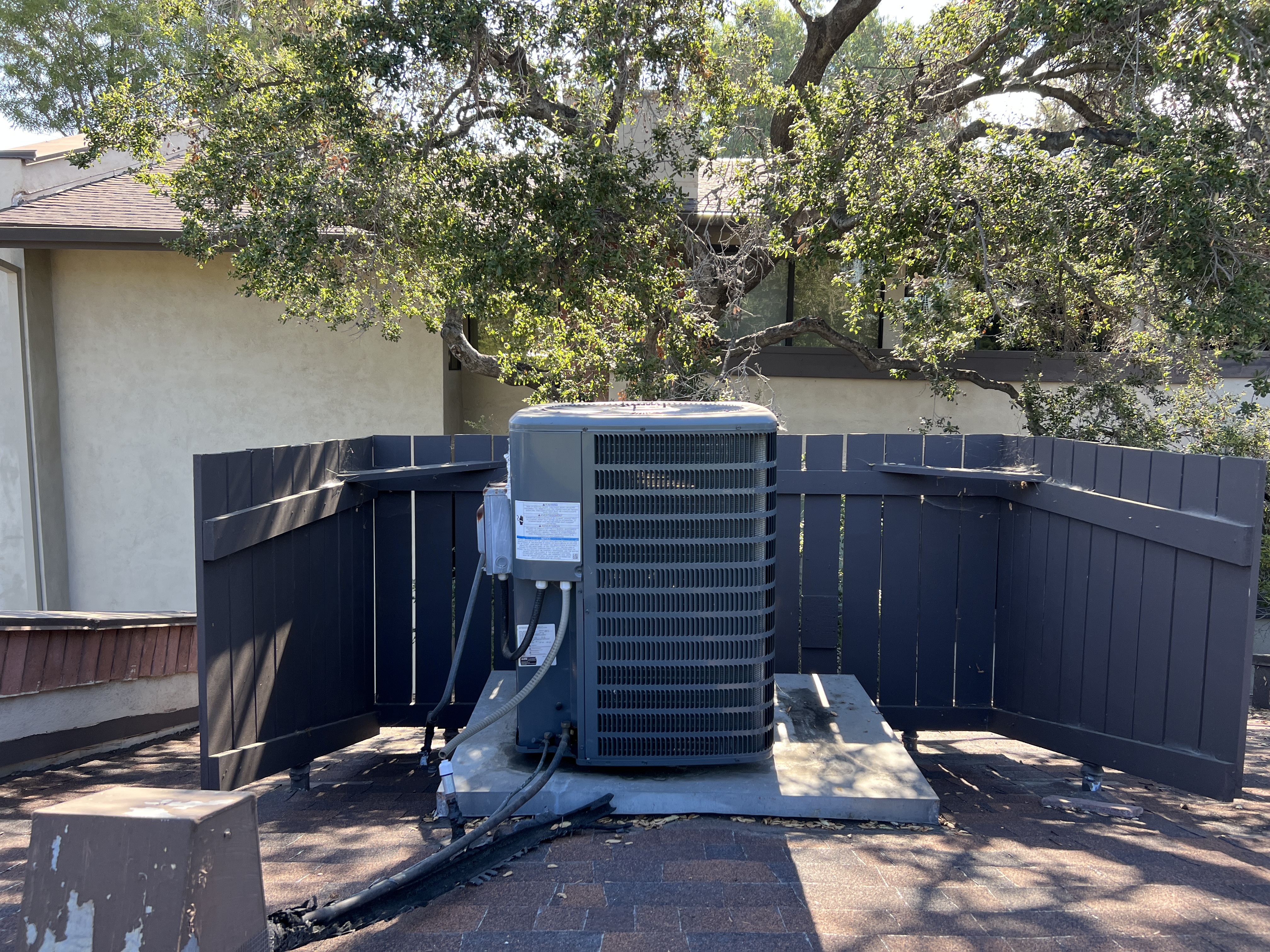 Image of a rooftop condenser unit, a key component in HVAC systems, installed on top of a commercial building against a clear sky. The metal casing and cooling fans are visible, symbolizing the essential process of heat exchange in air conditioning.