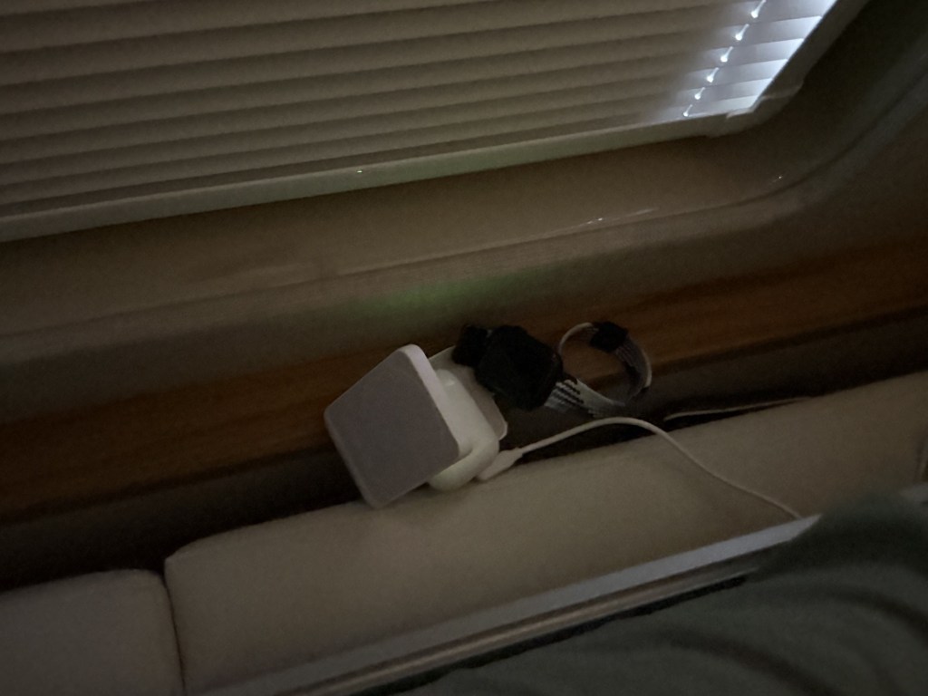 I tucked a phone/AirPods/watch charger behind the lounge seat cushion, and it was reachable from bed; we'll probably want to add a shelf there