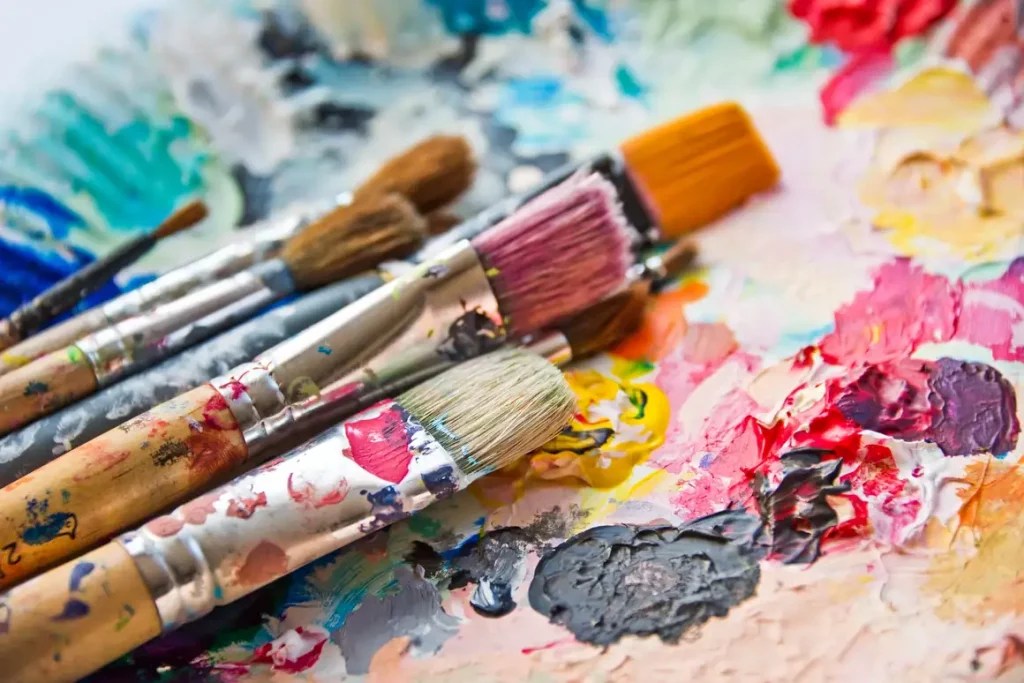 A palette of paint brushes on a white surface at a sip and paint in Washington DC.