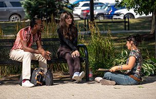 Students sit on campus, enjoying a beautiful day