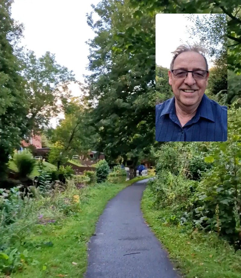 Mike walking along a quiet green canal path