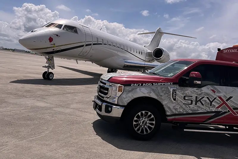 Sky X mobile AOG support truck parked beside a business jet on the ramp