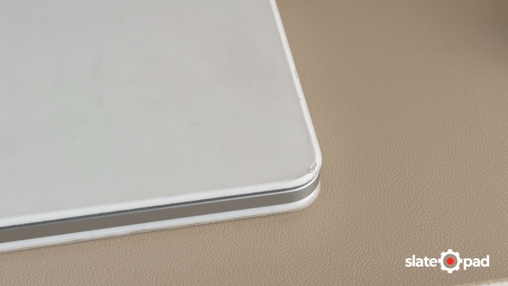 Corner of a white Magic Keyboard case with a ding on the corner.