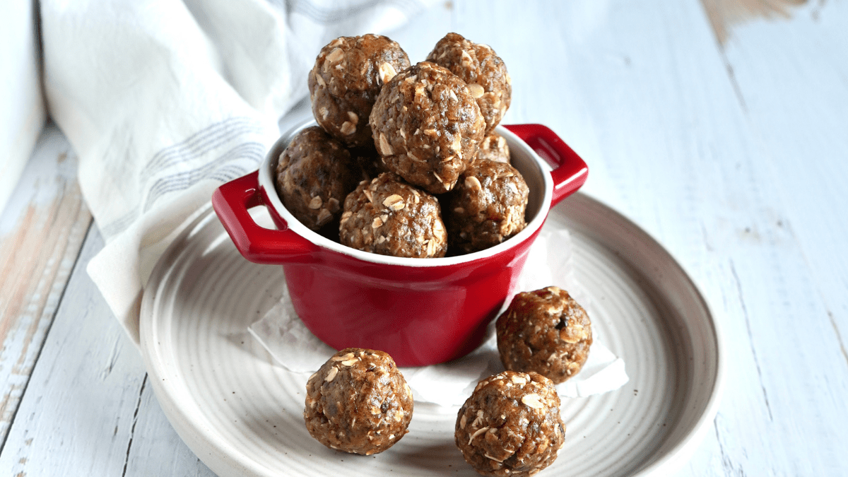 Red bowl sitting on a white plate with energy bites.