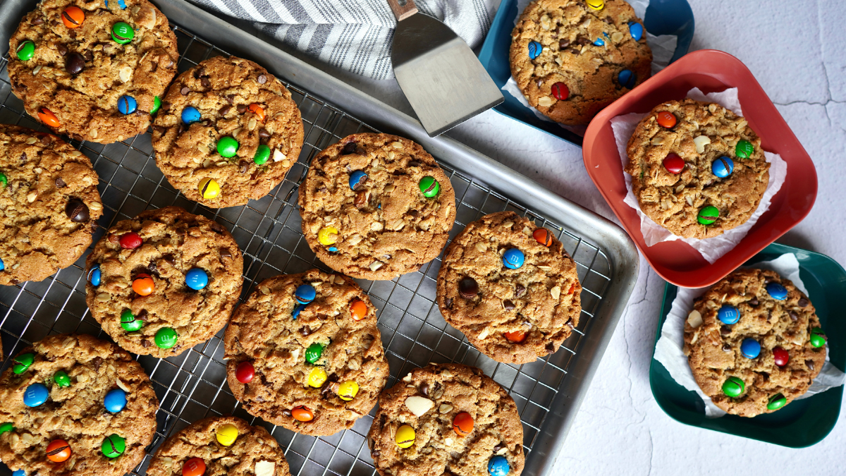 Tray of monster cookies with three small plates, each with a cookie on it.