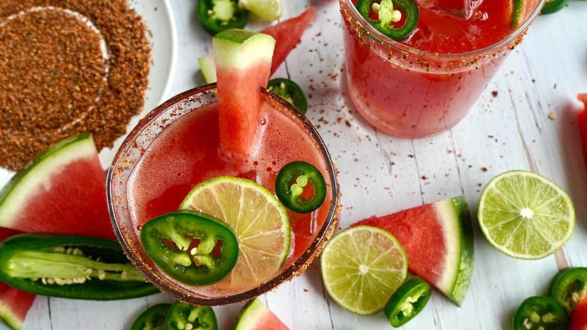 Pink watermelon margarita with slices of jalapeño, lime, and watermelon.