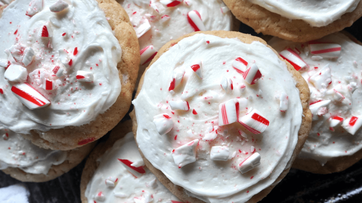Sugar cookies covered in cream cheese frosting and sprinkled with bits of candy cane.
