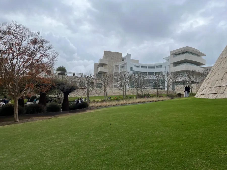 Gedung museum seni berwarna putih yang terlihat di seberang halaman rumput hijau