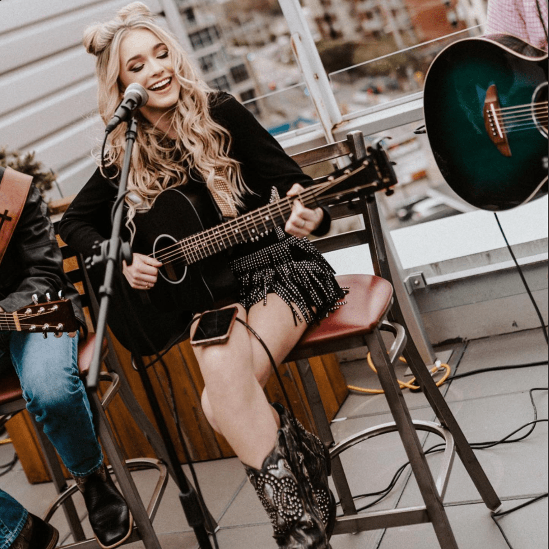 Brooklyn Summer playing guitar and singing.