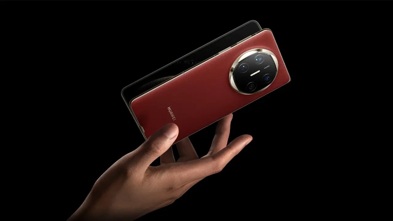 Hand holding Huawei Mate X6 foldable smartphone in red leather finish