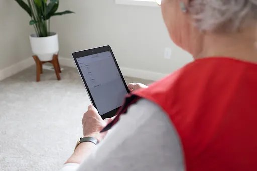 SmartVest patient using tablet while wearing vest.