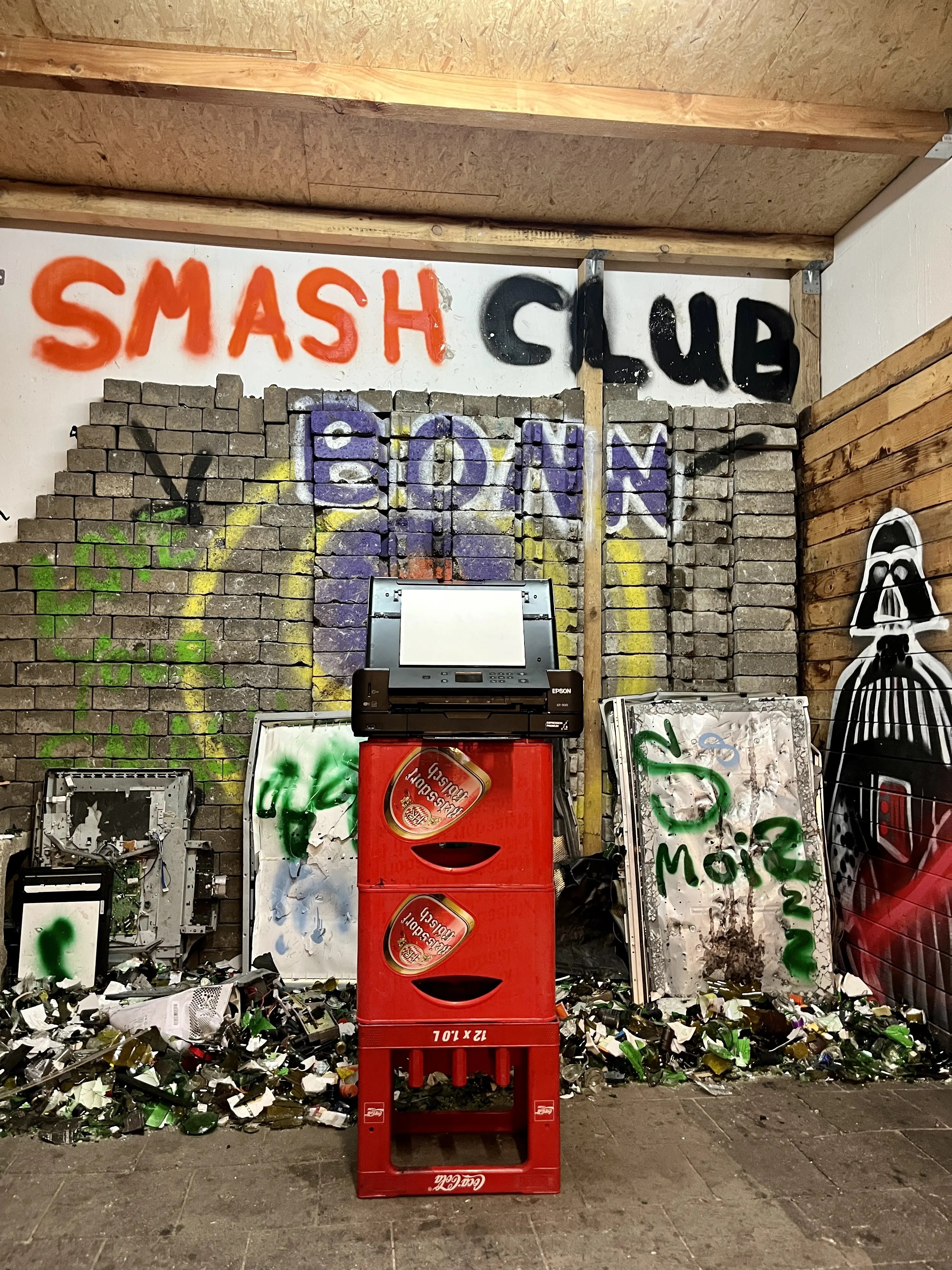 Drucker auf Bierkästen und Logo im Hintergrund im Classic-Smash Raum