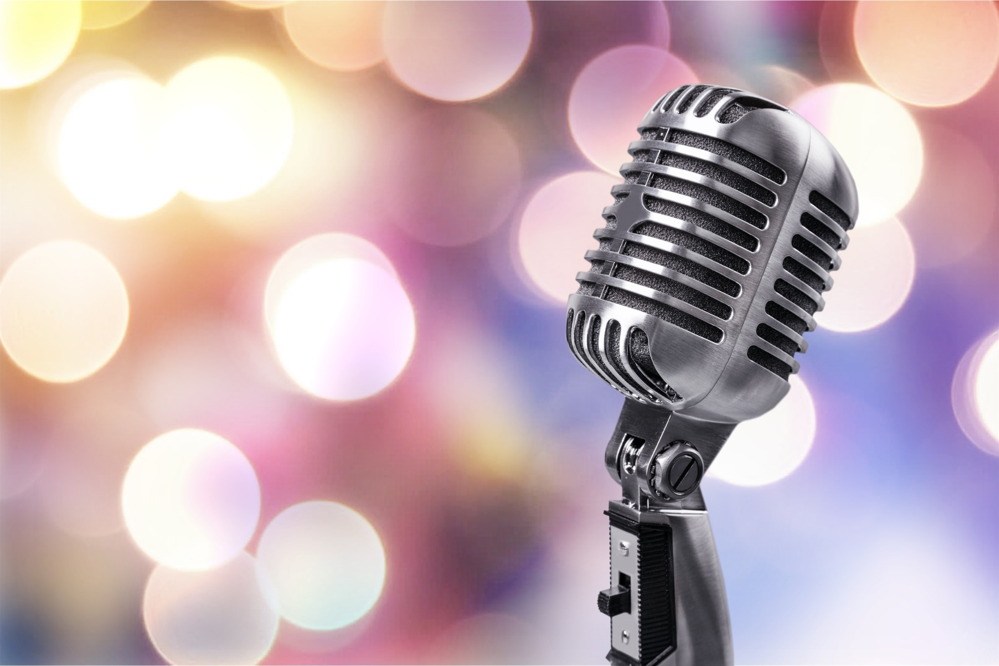 A vintage microphone against colorful event lights, representing professional MC services.