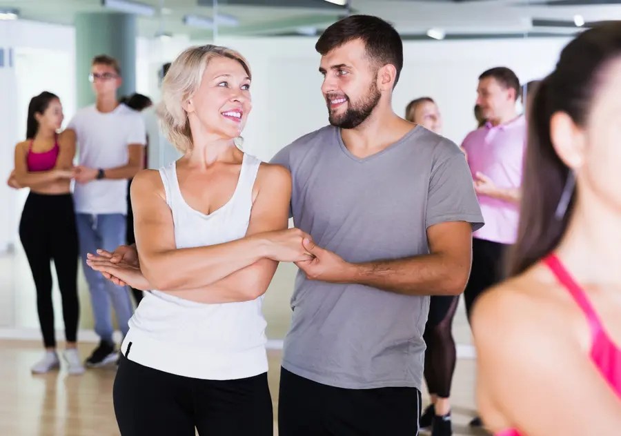 Adult couple smiling while practicing together in a private dance lesson